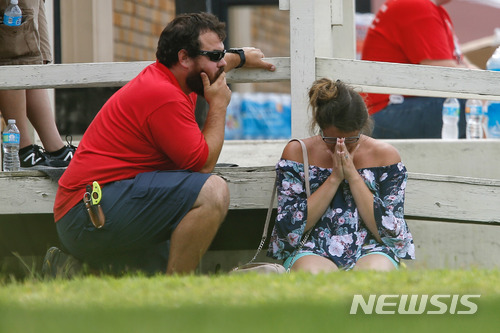【산타페=AP/뉴시스】 18일 아침(현지시간) 미국 텍사스주 휴스턴 인근 산타페 고등학교에서 총격사건이 발생해 8~10명 사망했다. 학부모로 보이는 여성이 학교 밖에서 자신의 아이가 무사하기를 기도하고 있다. 2018.05.19.