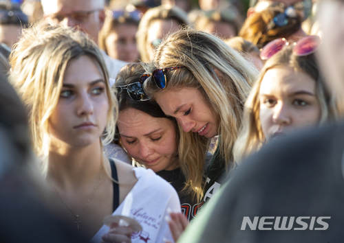 【산타페=AP/뉴시스】18일(현지시간) 미국 텍사스주 산타페 고교 총격 사건 희생자를 추모하는 기도회가 열린 가운데 참가들이 오열하고 있다. 용의자 디미트리오스 파구어티스(17)가 벌인 이번 총격으로 10명이 숨지고 13명이 부상당했다. 2018.05.19 
