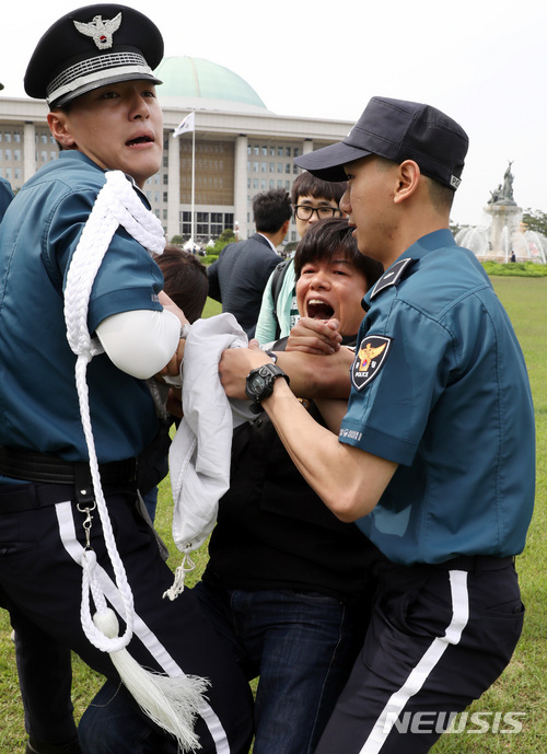 【서울=뉴시스】박영태 기자 = 21일 오후 서울 영등포구 여의도 국회로 진입한 민주노총 노조원들이 국회의 최저임금 개악논의 중단하라를 요구하며 시위를 하자 경찰들이 끌어내고 있다. 2018.05.21.since1999@newsis.com