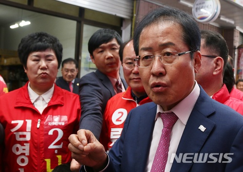 【제천=뉴시스】강신욱 기자 = 23일 오후 충북 제천 동문시장을 방문한 홍준표 자유한국당 대표가 취재진의 질문에 답하고 있다. 홍 대표는 강원랜드 사건을 수사하는 검찰의 고발장 대필에 강하게 비판했다. 2018.05.23. ksw64@newsis.com