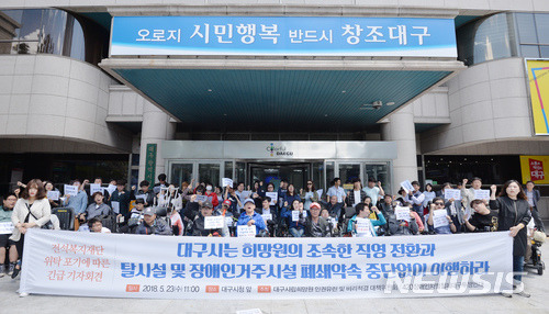 【대구=뉴시스】우종록 기자 = 대구희망원대책위와 420장애인차별철폐 대구투쟁연대가 23일 오전 대구 중구 동인동 대구시청 앞에서 기자회견을 열고 희망원의 조속한 직영 전환과 탈시설 및 장애인거주시설 폐쇄약속 중단 없이 이행할 것을 촉구하며 구호를 외치고 있다. 2018.05.23. wjr@newsis.com