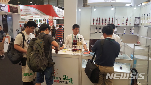 【영동=뉴시스】이성기 기자 = ‘대한민국 와인1번지’ 충북 영동군은 지역 와이너리 ‘월류원’이 세계시장 진출을 위해 중국 상하이 ‘시알차이나 2018’에 참가해 영동와인의 매력을 알렸다고 24일 밝혔다. 사진은 월류원 관계자가 관람객에게 와인을 홍보하는 모습이다.2018.05.24(사진=영동군 제공) sklee@newsis.com