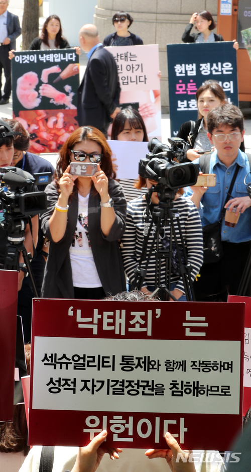 【서울=뉴시스】박주성 기자 = '낙태죄' 합헌에 대한 공개 변론일인 24일 오전 서울 종로구 헌법재판소 앞에서 낙태죄 합헌과 위헌을 촉구하는 시민단체 회원들이 피켓을 들고 기자회견을 하고 있다. 2018.05.24. park7691@newsis.com