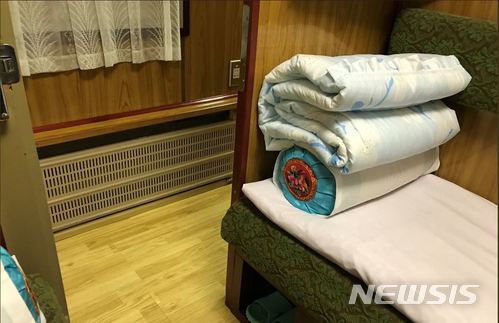 【서울=뉴시스】 24일 진행된 북한 풍계리 핵실험장 폐기식 취재진들이 이용한 전용열차 객실 내부. 객실 내부에는 간이 침대와 이불, 베개, 갈아신을 수 있는 슬리퍼가 구비돼 있었으며 생수와 탄산수, 탄산음료와 오미자차 등이 준비돼 있었다. <출처 = 이고리 즈다노프 트위터> 2018.05.25.