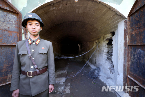 【서울=뉴시스】사진공동취재단 = 24일 북한 핵무기연구소 관계자들이 함경북도 길주군 풍계리 핵실험장 폐쇄를 위한 폭파 작업을 했다. 북한 군인이 핵실험장 3번 갱도 앞을 지키고 있다. 2018.05.25. photo@newsis.com