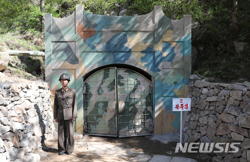 【서울=뉴시스】사진공동취재단 = 24일 북한 핵무기연구소 관계자들이 함경북도 길주군 풍계리 핵실험장 폐쇄를 위한 폭파 작업을 했다.&nbsp; 북한 군인이 2번 갱도 앞을 지키고 있다. 2018.05.25.&nbsp; photo@newsis.com