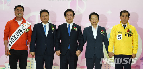 【수원=뉴시스】이정선 기자 = 이재명(더불어민주당), 남경필(자유한국당), 김영환(바른미래당), 이홍우(정의당), 홍성규(민중당) 경기지사 후보가 25일 오후 수원 경기도선거관리위원회에서 열린 제7회 전국동시지방선거 매니페스토 정책선거 실천 협약식에서 손을 서로 맞잡은 채 기념촬영을 하고 있다. 2018.05.25.&nbsp; ppljs@newsis.com