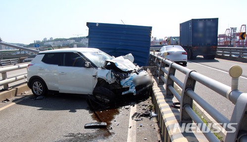 【부산=뉴시스】 하경민 기자 = 26일 오전 8시 58분께 부산 동구 충장고가로에서 부산세관 방향으로 달리던 트레일러에 실려 있던 컨테이너 박스가 반대편 차로로 떨어지면서 티볼리 승용차를 덮치는 바람에 승용차 앞범퍼 부분이 크게 파손되고 운전자 A(29)씨가 다쳐 인근 병원으로 옮겨져 치료를 받고 있다.2018.05.26. (사진=부산경찰청 제공)yulnetphoto@newsis.com
