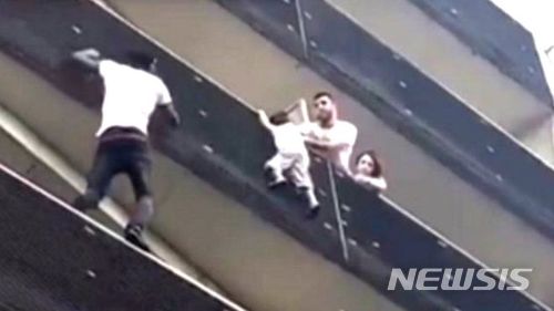 【서울=뉴시스】몇달 전 말리에서 프랑스로 이주한 마무드 가사마가 지난 26일 파리 18구역의 한 아파트에서 발코니에 위험하게 매달린 4살 남자아이를 구하기 위해 아파트 발코니를 오르고 있다. 아이를 구한 가사마는 프랑스에서 영웅으로 칭찬받고 있다. <사진 출처 : 페이스북> 2018.5.28