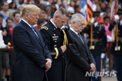 【알링턴(버지니아)=AP/뉴시스】도널드 트럼프 미국 대통령이 28일(현지시간) 미 버지니아주 알링턴 국립묘지 무명용사의 비에 헌화하고 기도하고 있다. 오른쪽에는 제임스 매티스 국방장관의 모습이 보인다. 2018.05.29.