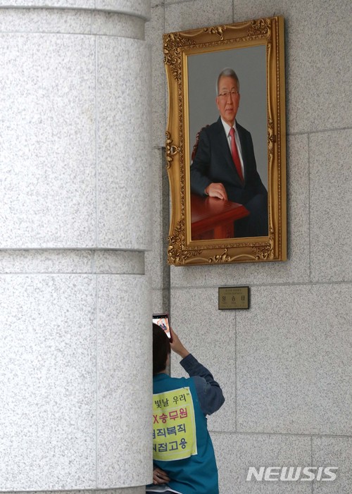 【서울=뉴시스】박진희 기자 = KTX 해고승무원이 29일 오후 서울 서초구 대법원 로비에 걸린 양승태 전 대법원장 초상화를 스마트폰으로 촬영하고 있다. 이날 전국철도노조 KTX열차승무지부와 KTX해고승무원 문제해결을 위한 대책위원회는 오전 11시30분께부터 서울 서초동 대법원 1층 대법정 앞에서 점거 시위를 하며 김 대법원장의 면담을 요구했다. 2018.05.29.pak7130@newsis.com