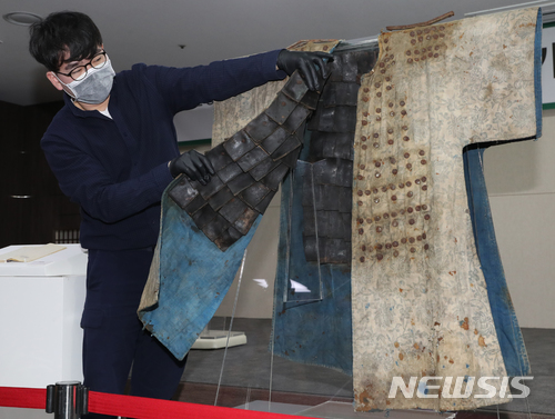 【서울=뉴시스】조수정 기자 = 30일 오전 서울 종로구 국립고궁박물관에서 한 직원이 조선 시대 갑옷 안쪽을 보여주고 있다. 안쪽에는 가죽으로 방호력을 높이기 위해 붙인 갑찰(미늘)이, 겉면에는 금속 두정, 어깨 견찰이 붙어 있다.&nbsp; 2018.05.30.&nbsp; chocrystal@newsis.com