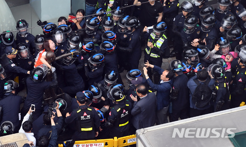 【부산=뉴시스】 하경민 기자 = 31일 부산 동구 일본총영사관 인근에서 동구청 직원 등이 인도 한복판에 놓여진 강제징용 노동자상을 강제 철거에 나선 가운데 경찰병력이 노동자상을 지키고 있던 시민단체 회원을 끌어내고 있다. 2018.05.31. yulnetphoto@newsis.com