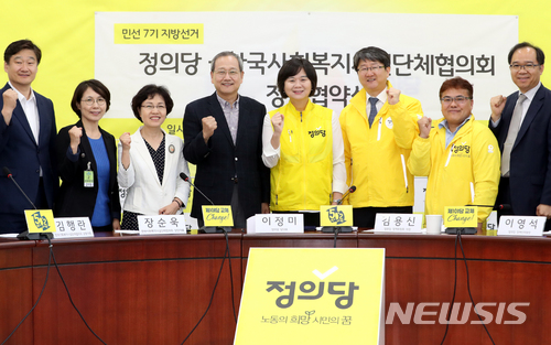 【서울=뉴시스】이종철 기자 = 정의당 이정미 대표(오른쪽에서 네번째)와 장순욱 한국사회복지시설단체협의회 상임대표(왼쪽에서 네번째)를 비롯한 참석자들이 1일 오전 서울 여의도 국회에서 열린 한국사회복지시설단체협의회와 정책협약 체결식에서 파이팅을 하고 있다. 2018.06.01. jc4321@newsis.com