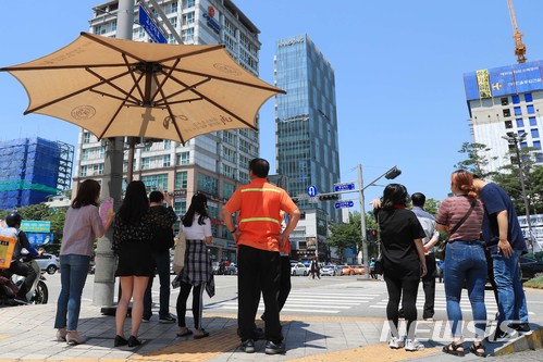 【서울=뉴시스】 한여름 날씨를 보인 1일 서울 성동구 왕십리 오거리 횡단보도에 설치된 무더위 그늘막 아래서 주민들이 뜨거운 햇볕을 피하고 있다. 2018.06.01. (사진=성동구 제공) photo@newsis.com