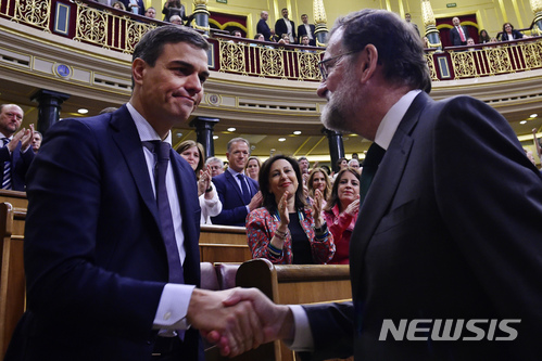 【마드리드=AP/뉴시스】 1일 스페인의 마리아노 라호이 총리(오른쪽)가 의회에서 사회당의 페드로 산체스 대표(왼쪽)가 발의한 자신에 대한 불신임안이 통과된 직후 의석으로 내려와 산체스 의원과 악수하고 있다. 현 총리에 대한 불신임안이 통과되면 발의자가 차기 총리가 되는 법에 따라 산체스는 국왕의 재가 후 총리에 취임한다. 350석중 과반선을 4석 넘긴 180명이 찬성했다. 2018. 6. 1.