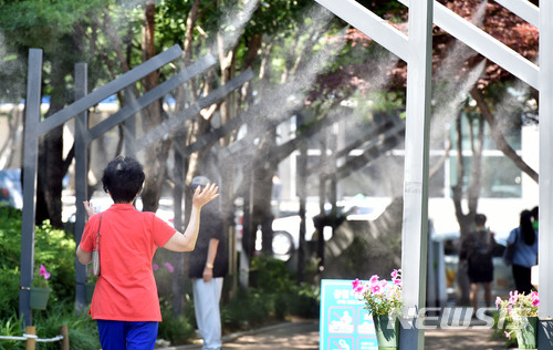 【대구=뉴시스】우종록 기자 = 대구 낮 기온이 32도를 웃도는 등 무더운 날씨를 보인 3일 오후 대구시 중구 공평동 2·28 기념중앙공원에서 시민들이 '쿨링포그'가 설치된 길을 걸으며 더위를 식히고 있다. 2018.06.03. wjr@newsis.com