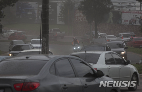 【과테말라시티 = AP/뉴시스】 푸에고 화산의 폭발로 분출된 화산재가 비처럼 쏟아져 내려 캄캄한 과테말라시티 시내에서 3일(현지시간) 운전자들이 도로 위를 조심스럽게 서행하고 있다.&nbsp;&nbsp;&nbsp; 