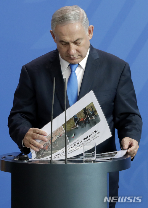 【베를린(독일)=AP/뉴시스】독일을 방문한 베냐민 네타냐후 이스라엘 총리가 4일 베를린에서 앙겔라 메르켈 독일 총리와의 공동기자회견 도중 파일들을 들쳐보고 있다. 이스라엘 정보기관 신베트는 5일 네타냐후 총리와 니르 바르카트 예루살렘 시장을 해치려는 음모를 적발해 저지했다며 동예루살렘 난민수용소의 팔레스타인 남성 1명을 이와 관련해 체포했다고 밝혔다. 2018.6.5