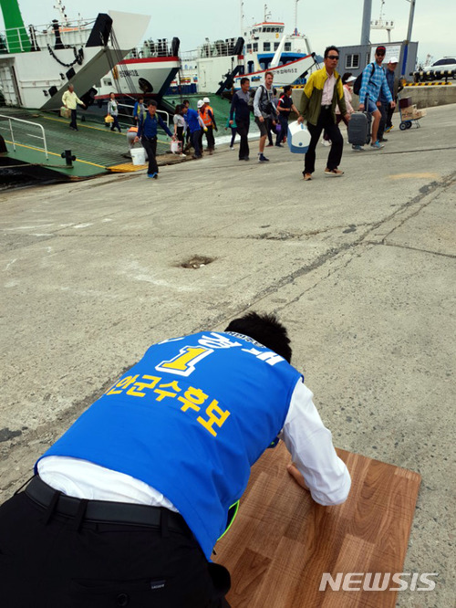 【신안=뉴시스】박상수 기자 = 민주당 천경배 신안군수 후보가 지난달 27일 목포 북항 선착장에서 주민들을 향해 큰 절을 올리고 있다. 2018.06.05. (사진=천경배 후보 선거사무소 제공) photo@newsis.com
