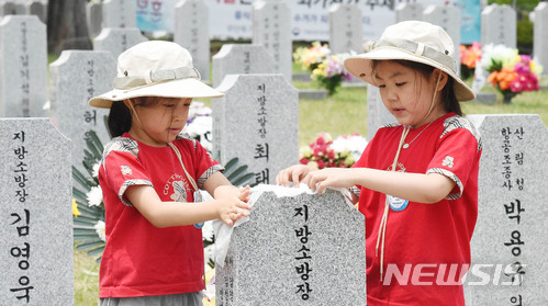 【대전=뉴시스】함형서 기자 = 청원초병설유치원 아이들이 현충일을 하루 앞둔 5일 오후 대전 유성구 국립대전현충원 소방공무원 묘역에서 묘비를 닦고 있다. 2018.06.05. foodwork23@newsis.com