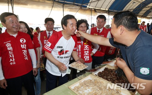 【충주=뉴시스】홍효식 기자 = 자유한국당 김성태 원내대표가 5일 오후 충북 충주시 풍물시장에서 상인이 건네주는 연근튀김을 맛보고 있다. 2018.06.05. yesphoto@newsis.com