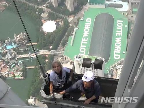 【서울=뉴시스】이예슬 기자 = 프랑스의 고층건물 등반가 알랭 로베르가 롯데월드타워를 오르다 경찰의 설득에 곤돌라를 타고 옥상으로 올라가고 있다. (제공=송파소방서)