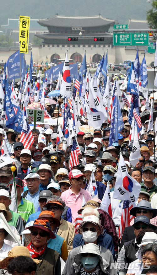 【서울=뉴시스】임태훈 기자 = 6일 오후 서울 종로구 교보빌딩 앞에서 열린 '자유민주주의 수호 국민대회'에서 보수단체 회원들이 태극기와 성조기를 들고, 애국가를 부르고 있다. 2018.06.06.taehoonlim@newsis.com