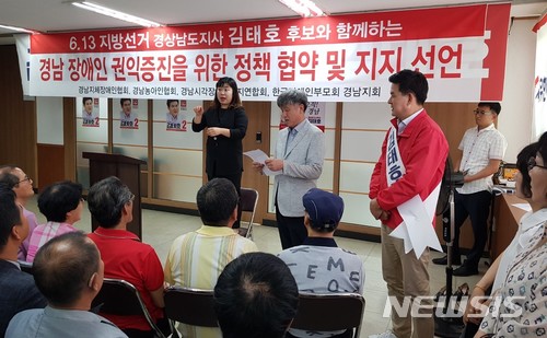 【창원=뉴시스】 홍정명 기자 = 7일 경남 창원 김태호 자유한국당 경남도지사 후보 선거사무소에서 김덕선 한국지체장애인협회 경상남도협회장이 김태호 후보가 지켜보는 가운데 경남 장애인 관련 4개 단체의 김태호 후보 지지 선언문을 낭독하고 있다.2018.06.07.(사진=김태호 후보 캠프 제공) photo@newsis.com