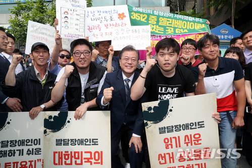 【서울=뉴시스】박진희 기자 = 문재인 대통령이 8일 오전 서울 종로구 청와대 인근 한 투표소에서 6·13 지방선거 및 국회의원 재보궐선거 사전투표를 마치고 장애인 참정권 요구하는 발달장애인들과 기념촬영을 하고 하고 있다.&nbsp; 현직 대통령이 사전투표에 참여하는 것은 2013년 상반기 재보선 때 사전투표제가 도입된 이후 이번이 처음이다. 2018.06.08. pak7130@newsis.com