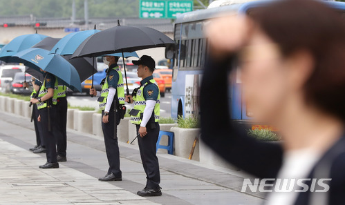 [서울=뉴시스]임태훈 기자 = 오존·자외선 농도가 전국적으로 나쁨 수준을 보인 2018년 6월8일 오후 서울 종로구 광화문 광장에서 경찰들이 햇볕을 피하기 위해 우산을 쓰고 있다. 2018.06.08.&nbsp; taehoonlim@newsis.com
