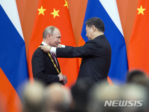【베이징=AP/뉴시스】8일 중국 베이징 인민대회당에서 시진핑 국가주석이 블라디미르 푸틴 러시아 대통령에게 첫 '우의훈장'을 수여하고 있다. 우의훈장은 중국 사회 현대화와 세계평화 수호에 기여하는 외국인에게 주려고 중국이 이번에 처음으로 만든 것으로, 푸틴 대통령이 첫 수상자가 됐다. 2018.06.08