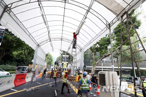 【싱가포르=뉴시스】조성봉 기자 = 북미정상회담을 사흘 앞둔 9일 오후 김정은 북한 국무위원장의 숙소인 싱가포르 세인트 리지스 호텔 앞에서 관계자들이 가리막 설치를 하고 있다.&nbsp; 김정은 국무위원장의 숙소인 세인트 리지스 호텔 옆은 이날부터 14일까지 버스가 하차하지 않으며, 차량의 진입이 전면 통제된다. 2018.06.09. suncho21@newsis.com 