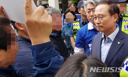 【제주=뉴시스】조수진 기자 = 홍영표 더불어민주당 원내대표가 10일 오전 제주시 노형동에 위치한 문대림 제주지사 후보 선거사무소에서 기자회견을 마치고 나오며 최저임금 개정안을 규탄하는 민주노총 제주본부와 만나고 있다. 2018.06.10. (사진=독자 제공) photo@newsis.com