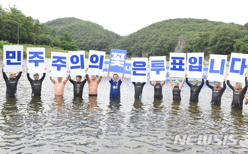 【울산=뉴시스】배병수 기자 = 더불어민주당 송철호 울산시장후보는 10일 울산시 울주군 범서읍 선바위 앞에서 사전투표율 20%초과에 따른 시민들과의 약속을 지키기 위해 입수를 한 뒤 수영동호인들과 함께 투표독려를 하고 있다. 2018.06.10.  bbs@newsis.com.