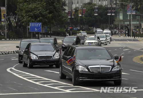 【싱가포르=AP/뉴시스】김정은 북한 국무위원장을 태운 것으로 추정되는 검은색 차량 행렬이 10일 북한 인공기를 단 채 싱가포르의 오차드로를 질주하고 있다. 2018.6.10