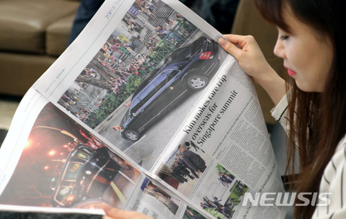 【싱가포르=뉴시스】박주성 기자 = 북미정상회담을 하루 앞둔 11일 오전 싱가포르 한 호텔에서 시민들이 싱가포르 신문에 난 도널드 트럼프 미국 대통령과 김정은 북한 국무위원장의 소식을 보고 있다. 2018.06.11.&nbsp; park7691@newsis.com