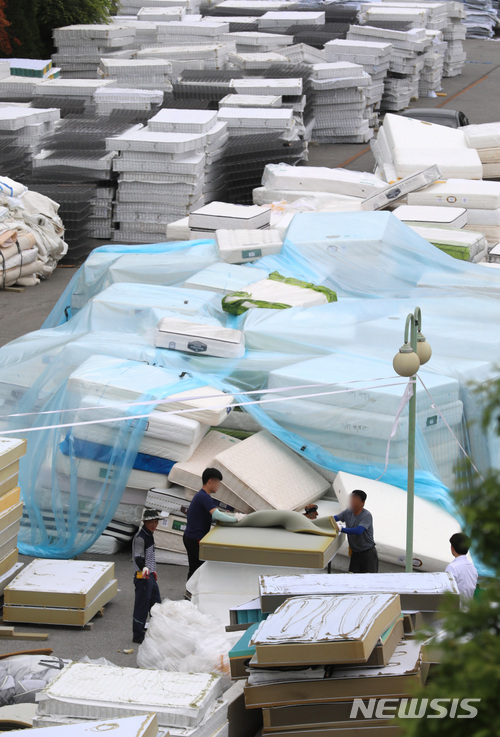 【천안=뉴시스】강종민 기자 = 11일 오후 충남 천안시 직산읍 대진침대 본사 앞마당에서 관계자들이 방사성 물질 '라돈'이 검출돼 수거된 침대 매트리스 해체 작업을 하고 있다. 우정사업본부는 대진침대로부터 수거 요청을 받은 매트리스를 오는 16일과 17일 이틀동안 집중 수거할 예정이다. 2018.06.11. ppkjm@newsis.com