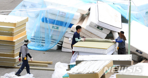 【천안=뉴시스】강종민 기자 = 11일 오후 충남 천안시 직산읍 대진침대 본사 앞마당에서 관계자들이 방사성 물질 '라돈'이 검출돼 수거된 침대 매트리스 해체 작업을 하고 있다.우정사업본부는 대진침대로부터 수거 요청을 받은 매트리스를 오는 16일과 17일 이틀동안 집중 수거할 예정이다. 2018.06.11. ppkjm@newsis.com