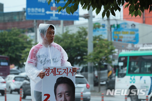 【서울=뉴시스】홍효식 기자 = 남경필 자유한국당 경기도지사 후보가 11일 오후 고양시 일산 서구에서 우비를 입고 시민들에게 지지를 호소하고 있다. 2018.06.11.(사진=남경필 후보 캠프제공) photo@newisis.com