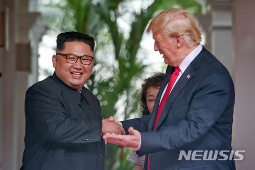 【서울=뉴시스】 역사적 첫 북미정상회담이 열린 12일 오전 회담장인 카펠라 호텔에 북한 김정은 위원장과 미국 트럼프 대통령이 회담을 위해 만나고 악수를 나누고 있다. 2018.06.12. (사진=싱가포르 통신정보부 제공) photo@newsis.com