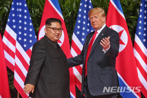 【서울=뉴시스】 역사적 첫 북미정상회담이 열린 12일 오전 회담장인 카펠라 호텔에 북한 김정은 위원장과 미국 트럼프 대통령이 회담을 위해 만나고 기념촬영을 하고 있다. 2018.06.12. (사진=싱가포르 통신정보부 제공) photo@newsis.com