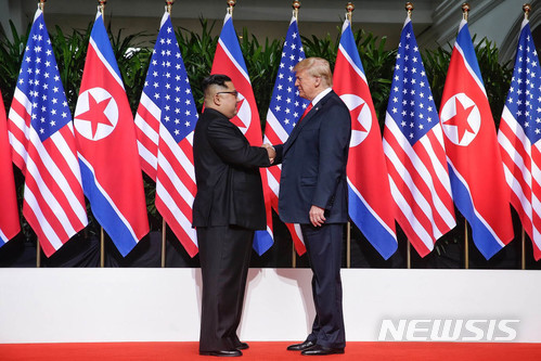 【서울=뉴시스】 역사적 첫 북미정상회담이 열린 12일 오전 회담장인 카펠라 호텔에 북한 김정은 위원장과 미국 트럼프 대통령이 회담을 위해 만나고 악수를 나누고 있다. 2018.06.12. (사진=싱가포르 통신정보부 제공)&nbsp; photo@newsis.com 