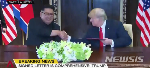 【서울=뉴시스】 12일 김정은 북한 국무위원장과 도널드 트럼프 미국 대통령이 싱가포르 센토사섬 카펠라 호텔에서 북미정상회담 합의문 서명을 한 뒤 악수하고 있다. 2018.06.12. (사진=채널아시아 방송 캡쳐)&nbsp; photo@newsis.com