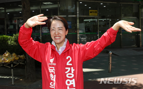 【서울=뉴시스】홍효식 기자 = 제7회 전국동시지방선거 및 국회의원 재·보궐선거를 하루 앞둔 12일 서울 노원구 상계 11-13단지 사거리에서 강연재 자유한국당 서울 노원구병 국회의원 후보가 선거운동원을 향해 손을 흔들고 있다. 2018.06.12. yesphoto@newsis.com