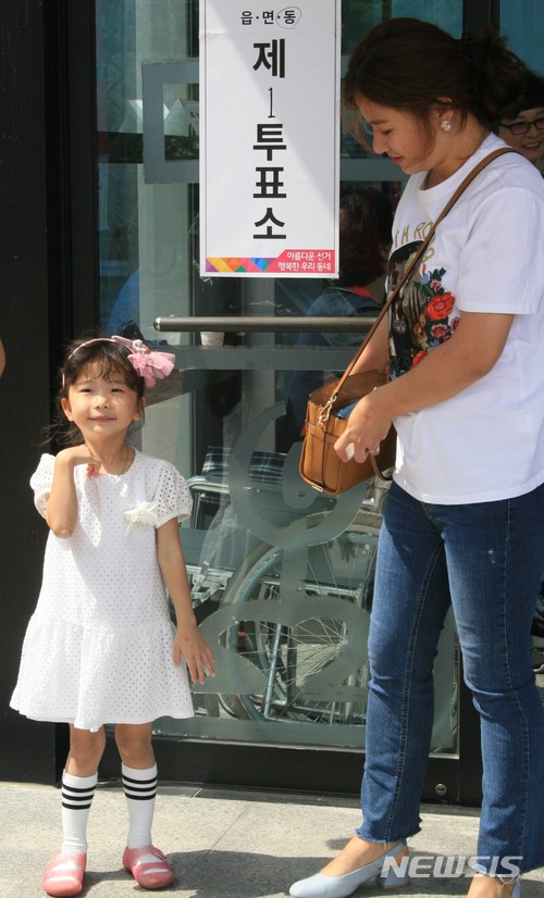 【춘천=뉴시스】박종우 기자 = 13일 오전 강원 춘천시 효자동 몸짓극장에 설치된 투표소에서 한 아이가 해맑게 웃고 있다. 2018.06.13&nbsp;&nbsp; jongwoo425@newsis.com 