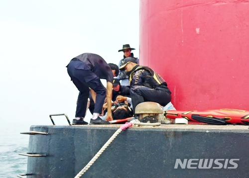  【부안=뉴시스】고석중 기자 = 13일 오전 11시56분께 전북 부안군 위도면 치도리 항로표지구역에서 발생한 40대 낚시꾼을 해경이 구조하고 있다. 2018.06.13. (사진= 부안해경 제공) photo@newsis.com