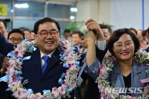 【창원=뉴시스】강경국 기자 = 6·13 지방선거 창원시장 선거 개표율이 15.2%인 가운데 13일 오후 11시25분 현재 1위(44.5%)를 달리고 있는 허성무 더불어민주당 후보가 부인 이미숙씨와 함께 손을 들고 미소를 짓고 있다. 2018.06.13. kgkang@newsis.com