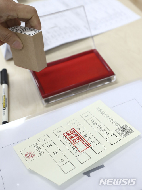 무효표는 투표용지를 투표참관인이 확인한 뒤 무효표를 알리는 도장을 찍어 처리한다. 사진은 13일 오전 서울 방배3동주민센터에 차려진 방배3동 제1투표소에서 투표사무원이 유권자가 놓고 간 투표용지에 무효표를 알리는 도장을 찍고 있는 모습. 2018.06.13.myjs@newsis.com 
