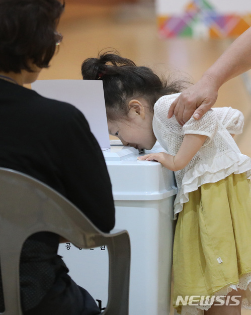 【세종=뉴시스】강종민 기자 = 제7회 전국동시지방선거일인 13일 오전 세종시 도담동의 한 투표소에서 할머니와 함께 투표소를 찾은 어린이가 투표함이 궁금한 듯 빼꼼히 살펴보고 있다. 2018.06.13.&nbsp; ppkjm@newsis.com